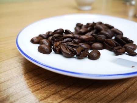 Coffee beans  on white ceramic dishの写真素材