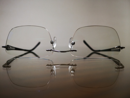 Close up eyeglasses and reflection on glass ground
