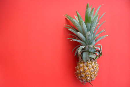 Phu Lae pineapple isolated over red background with space for text