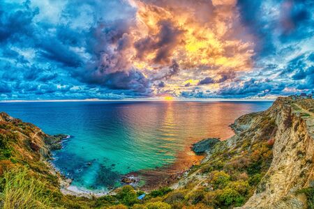 Beautiful colorful sunset at the sea with dramatic clouds. Panoramic view. Beauty world, nature and outdoors travel concept. Volcanic hills in the background. Composition of natureの写真素材