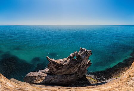 The rock or lava formation with the shape of a large animal or dragon head arise from the water....