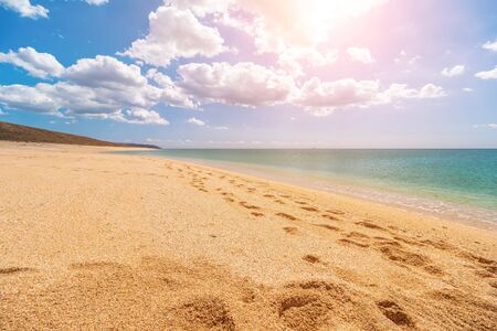 Empty, deserted golden beach with shell sand and crystal clear azure sea. blurred background for your text. concept of travel, ideal place for summer vacation by the sea in a safe place. Copy space.の写真素材