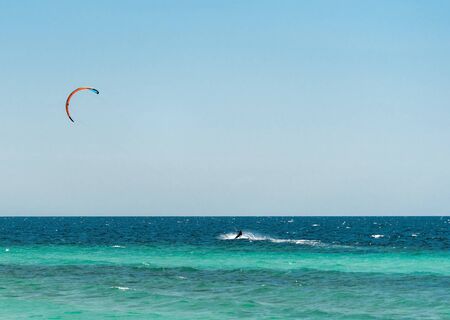 Extreme water sport - kitesurfing at sea on hot summer sunny day Copy space. The concept of an...