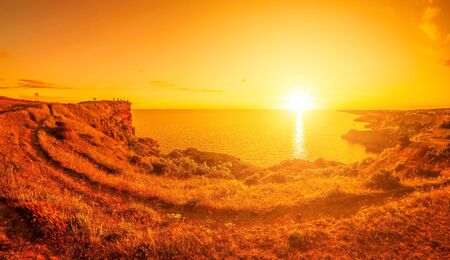 Panoramic seascape, view on rocky seashore, calm azure sea and red burning sunset. Copy space. Copy space. Beauty world, nature and outdoors travel concept.の写真素材