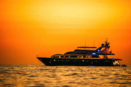Golden romantic sunset on private modern luxury yacht anchored at sea - luxury holidays and travel...