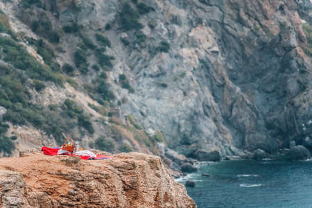 Picnic at the autumn seascape with volcanic rocky coastline. Calm sea against the backdrop of rocky...