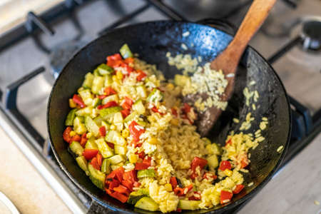 a big pilaf pan bowl with mix of vegetables, cooking on the kitchenの写真素材