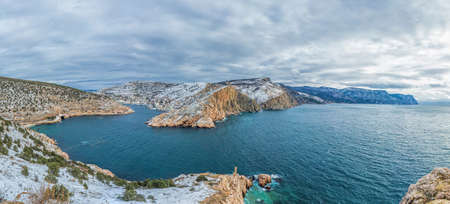 A picturesque panoramic view of the winter snow-covered Balaklava Bay, the ruins of the Genoese...