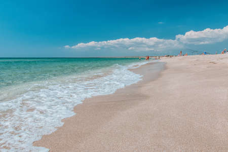Deserted beach with white sand and crystal clear azure sea. blurred background for your text. concept of travel, ideal place for summer vacation by the sea in a safe place. Copy space.の写真素材