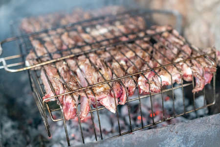 Lamb ribs cooked over an open fire, close-up. Lamb chops Grilling Barbecue, BBQ Originally made from...