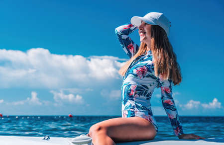 Healthy happy fit woman in bikini relaxing on a sup surfboard, floating on the clear turquoise sea...