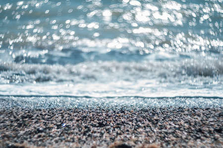 Abstract nature summer or spring ocean sea background. Small waves on golden warm water surface in motion blur with bokeh lights from sunset. Holiday, vacation and recreational background conceptの写真素材