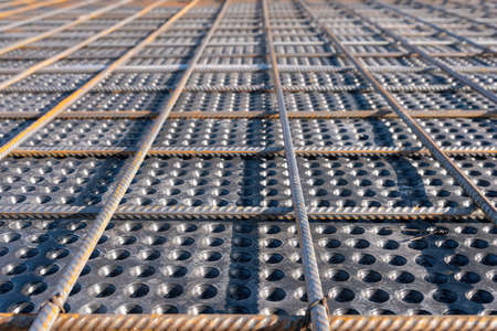 Close up view of reinforcement of concrete. Geometric alignment of Rebars on construction site. Reinforcements steel bars stack.の写真素材