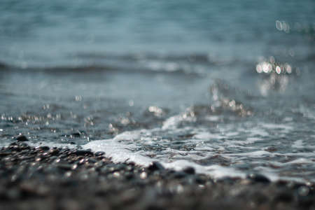 Abstract nature summer ocean sunset sea background. Small waves on water surface in motion blur with...