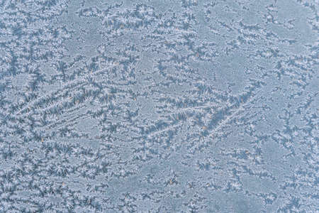 Selective focus. First frost on a frozen car, late autumn close-up. Beautiful abstract frozen microcosmos pattern. Freezing weather frost action in nature. Winter backdrop.の写真素材