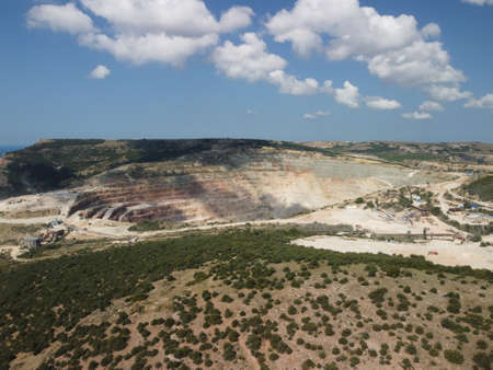 Aerial view industrial of opencast mining quarry with lots of machinery at work - extracting fluxes...