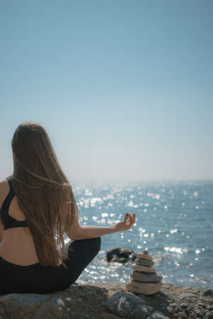 Young woman with long hair, fitness instructor in Sportswear Leggings and Tops, stretching before...