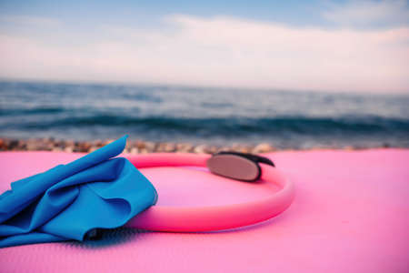 Magic pilates ring and rubber band on yoga mat near sea Female fitness yoga concept. Healthy lifestyle harmony and meditation.の写真素材