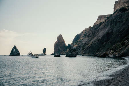 Dramatic Seascape over the beach during sunset, with rocky volcanic cliff is lit by the warm sunset....