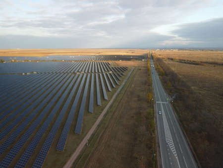 Aerial top view of a solar panels power plant. Photovoltaic solar panels at sunrise and sunset in countryside from above. Modern technology, climate care, earth saving, renewable energy concept.の写真素材