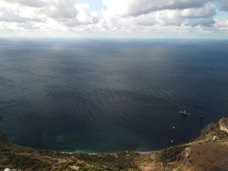 Abstract airy sky with moving plump clouds over the sea ocean. Small waves on clear water surface bokeh lights from sunrise. Holiday, vacation and recreational conceptの写真素材