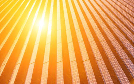 Aerial top view of a solar panels power plant. Photovoltaic solar panels at sunrise and sunset in countryside from above. Modern technology, climate care, earth saving, renewable energy concept.の写真素材