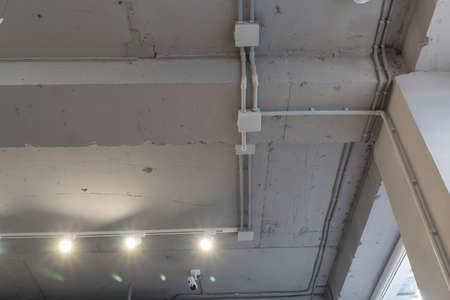 Abstract loft interior of concrete grey ceiling with air ventilation and security camera. Interior...