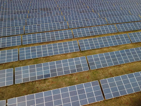Aerial top view of a solar panels power plant. Photovoltaic solar panels at sunrise and sunset in...