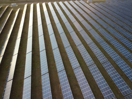 Aerial top view of a solar panels power plant. Photovoltaic solar panels at sunrise and sunset in countryside from above. Modern technology, climate care, earth saving, renewable energy concept.の写真素材