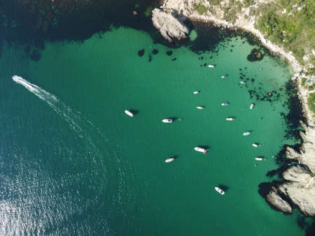 Aerial panoramic view of seascape with crystal clear azure sea and rocky shores. Yachts in a beautiful lagoon on backdrop of rocks. The concept of an ideal destination for summer travel and vacation.の写真素材