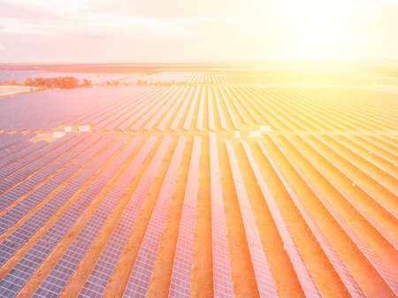 Aerial top view of a solar panels power plant. Photovoltaic solar panels at sunrise and sunset in...