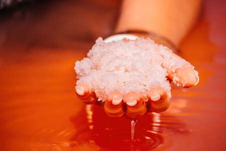 Young woman with long hair in pink salty lake with crystals of salt. Extremely salty pink lake, colored by microalgae with crystalline salt depositions. Spa, beauty and health care concept.の写真素材