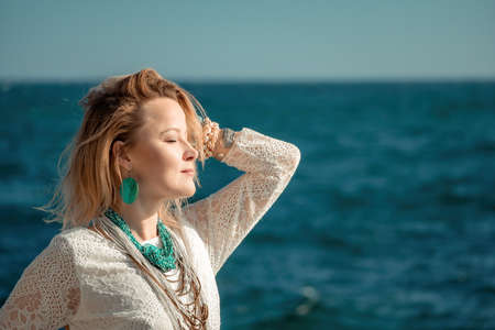 Woman in bohemian clothing on beach at sunset. Boho style for fashionable look on resort. Middle...