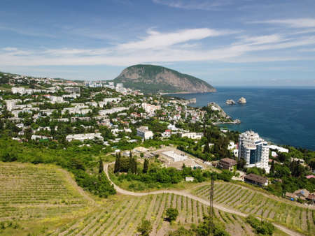 Aerial panoramic view on Gurzuf resort city and Bear Mountain, Ayu-Dag, Yalta, Crimea. Spring sunny day. Nature summer ocean sea beach background. Vacation, travel and holiday concept.の写真素材