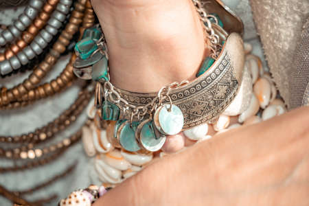 Close up of beautiful tribal boho style woman hands with lots of accessories. Boho style for...