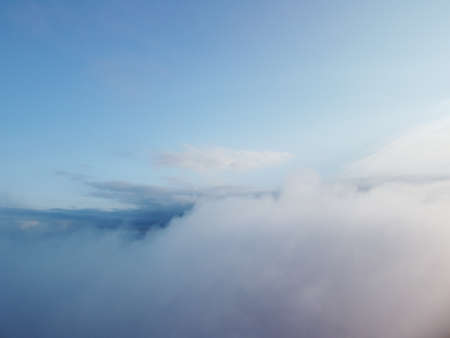 Aerial view. Blue sky sun and fog over calm sea. The drone flies over foggy and fluffy clouds. Abstract aerial nature summer ocean sunset sea and sky background. Vacation, travel and holiday concept.の写真素材