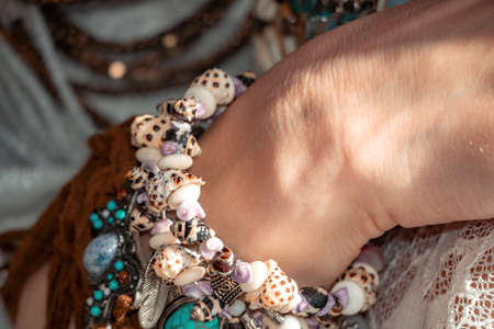Close up of beautiful tribal boho style woman hands with lots of accessories. Boho style for...