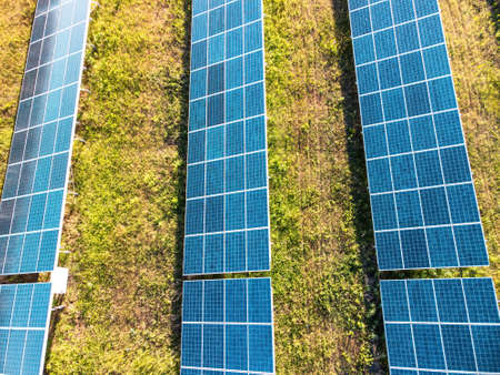 Aerial top view of a solar panels power plant. Photovoltaic solar panels at sunrise and sunset in...