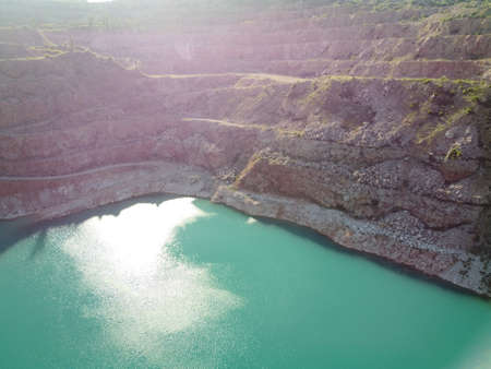 Aerial top view on opencast mining quarry with flooded bottom, turquoise surface of the lake. Quarry...