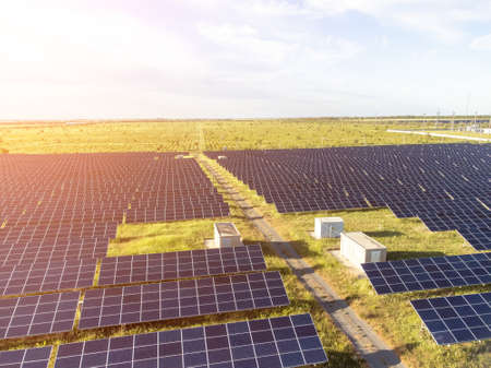 Aerial top view of a solar panels power plant. Photovoltaic solar panels at sunrise and sunset in...