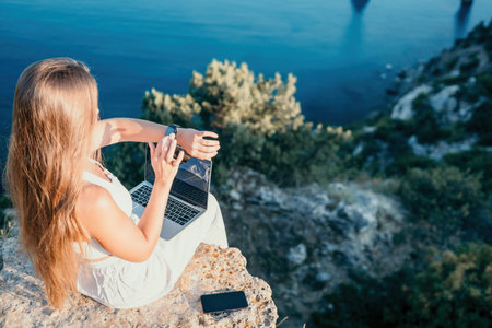 Digital nomad, Business woman working on laptop by the sea. Pretty lady typing on computer by the...