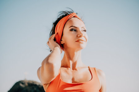 Woman sea yoga. Selective focus. Young beautiful caucasian woman in a red suit practicing yoga on the beach at sunrise near the sea. Yoga. Healthy lifestyle. Meditation concept.の写真素材