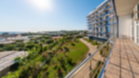 Abstract defocused sea view with clear blur sky, view from high floor of luxury hotel apartment room terrace. Blurred background view from the balcony to the sea on sunny day. City near the sea.の写真素材