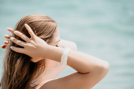 Close up Yoga Hand Gesture of Woman Doing an Outdoor meditation. Blurred sea background. Woman on yoga mat in beach meditation, mental health training or mind wellness by ocean, seaの写真素材