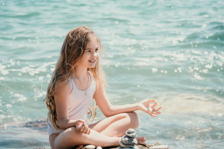 Woman with daughter bilds stones pyramid on seashore on a sunny day on the blue sea background. Happy family holidays. Pebble beach, calm sea. Concept of happy vacation on the sea, meditation, spaの写真素材