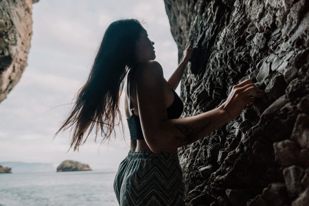 Sports Woman Climbing The Rock. Young woman With slim fit body cの写真素材