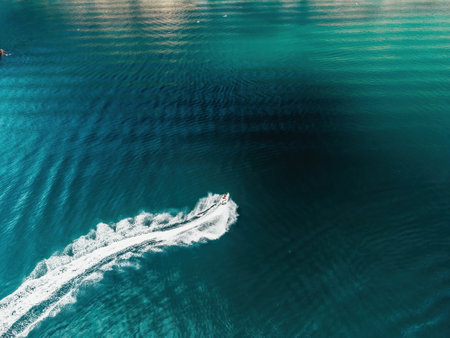 High speed water bike leaving abstract white footprints on the sea water. Aerial top view on Water...