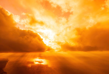 Aerial view red burning sunset over the sea with rocky volcanic cliff. Abstract nature summer sunset...