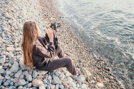 Woman travel sea. Happy tourist enjoy taking picture outdoors for memories. Woman traveler looks at...