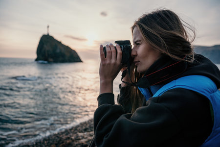 Woman travel sea. Happy tourist enjoy taking picture outdoors for memories. Woman traveler looks at sea bay of mountains, sharing travel adventure journeyの写真素材